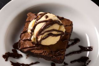 Brownie with ice cream on white plate